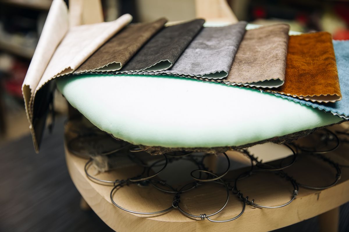 Interior de silla con muelles, espuma y muestras de tela en taller